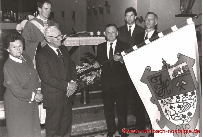1990 - Weihe des neuen Familienbanners durch Kaplan Matthias Köller. Auf dem Foto, die beiden noch lebenden Kinder von " Doppeljäb " Barbara Müller und Jakob Jacob junior. Das Familienbanner hält Franz Jacob. Daneben die beiden Kinder von Barbara Müller, Kurt und Günter