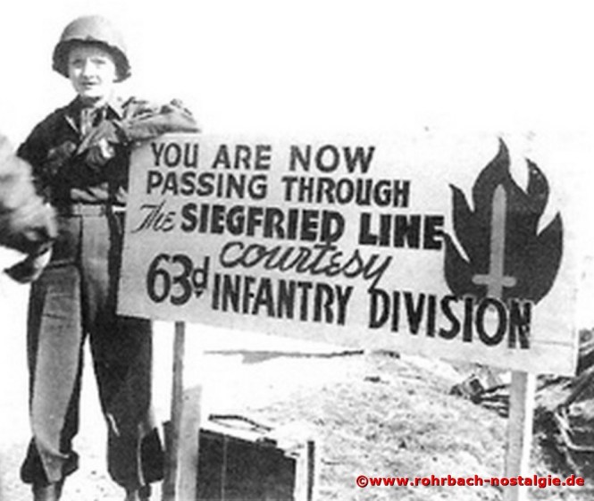 * Marlene Dietrich vor einem Schild der 63. Infanterie Division der US Army in Kirkel, die den Westwall überwand