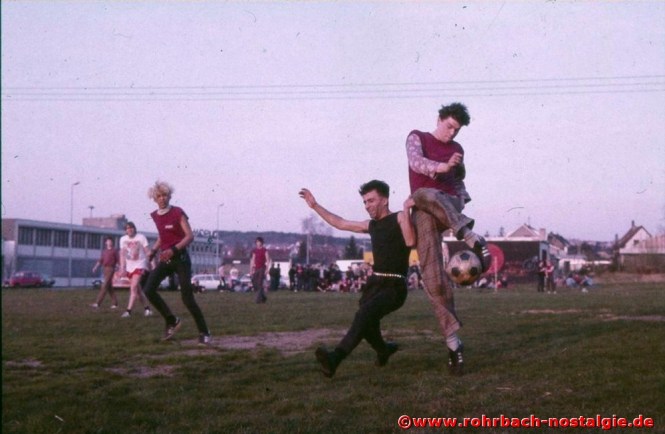 1984 am Ostersamstag. Campino und seine Freunde spielen gegen eine Rohrbacher Fußballmannschaft auf einer Wiese vor dem Umspannwerk. Im Hintergrund die Punkkneipe Tote Hose