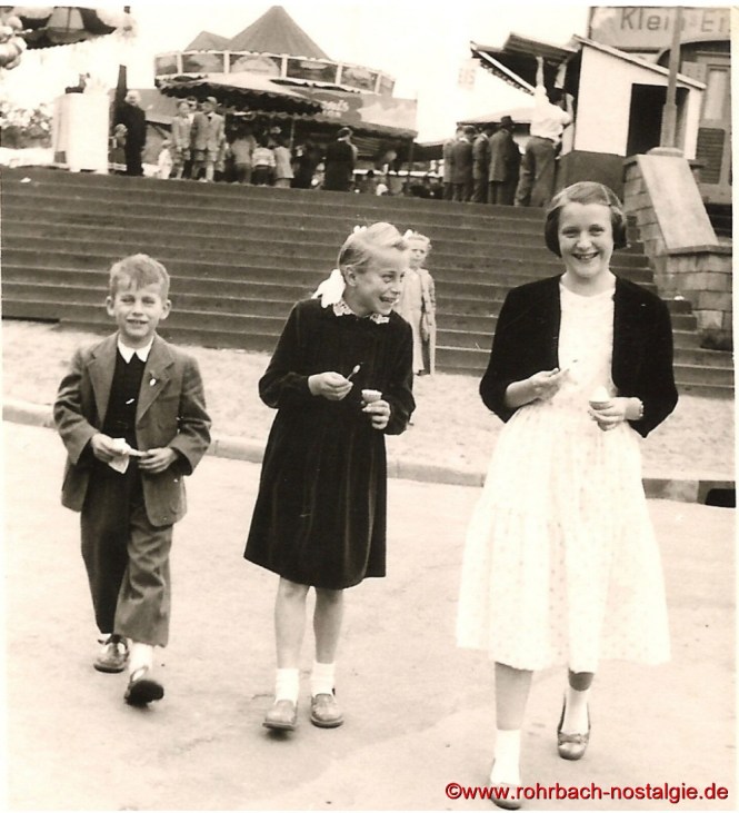 1956 Blick von der Bahnhofstraße auf den Marktplatz mit den Karussells und den Verkaufsständen. Auf dem Foto die Kinder Karl und Anita Abel sowie Margarete Jakob